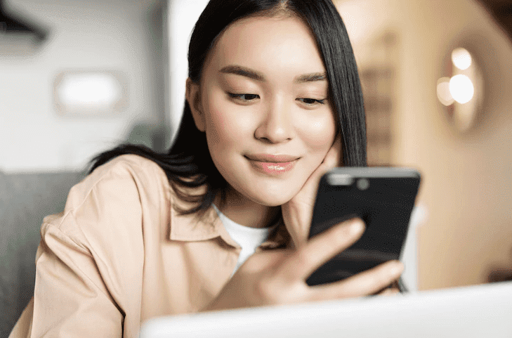 a girl smiles when checking her phone